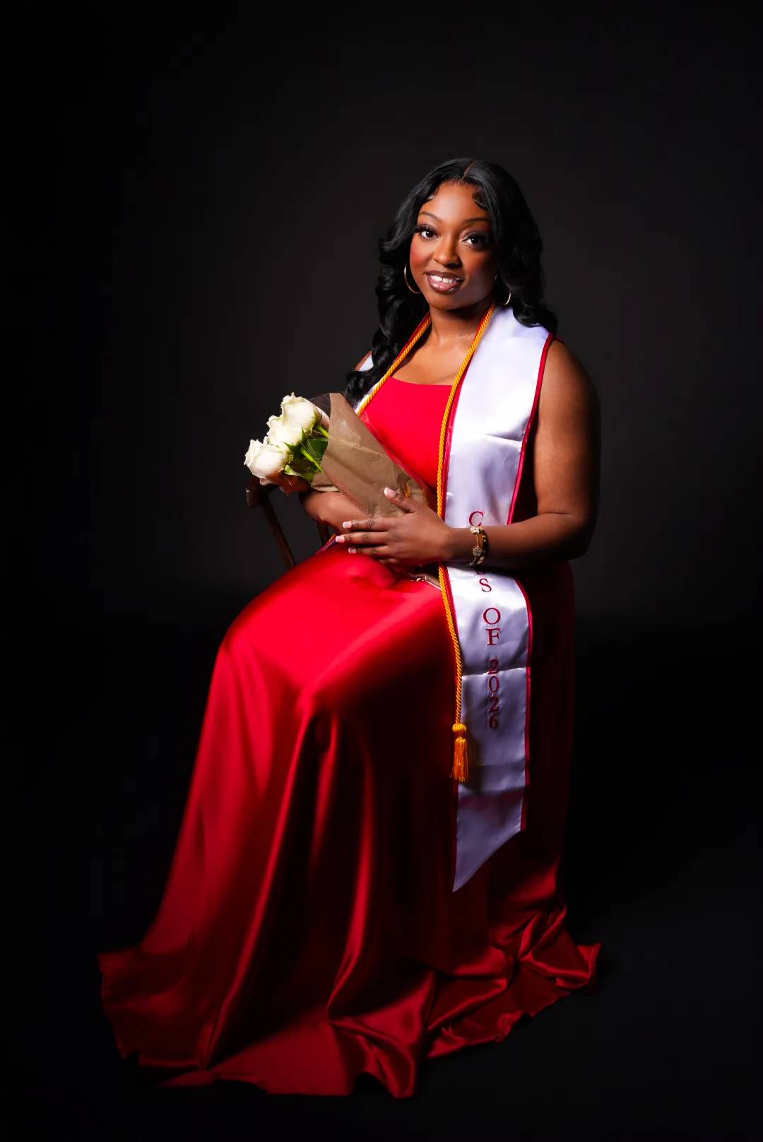 Graduation portrait — red gown, black backdrop